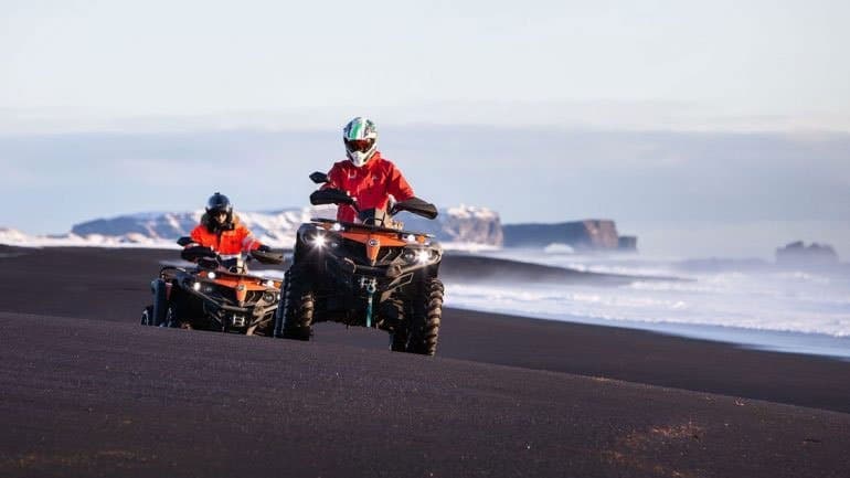 dos ATV's en una playa de arena negra en el sur de Islandia