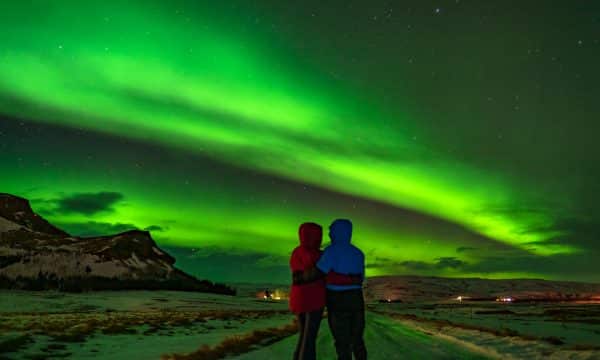 Dos personas mirando la aurora boreal.