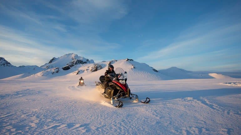 Motoneiges sous le soleil sur le glacier Langjokull en Islande
