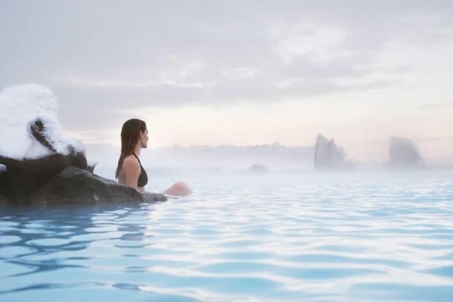 Une femme se détendant dans les eaux bleues des bains naturels de Mývatn dans le nord de l'Islande