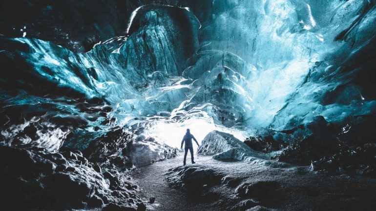 Un voyageur au fond d'une grotte de glace islandaise