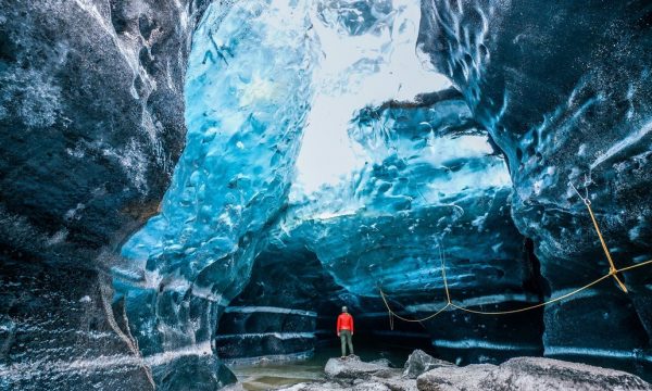 Un homme debout à l'intérieur d'une grotte de glace en Islande.