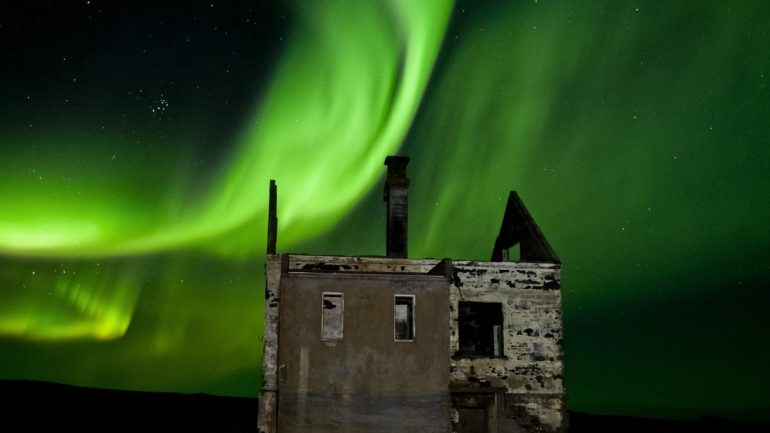 Aurores boréales au-dessus d'une maison abandonnée en Islande.