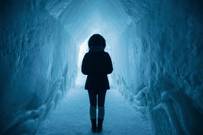 A woman inside Iceland's Ice Cave Tunnels.