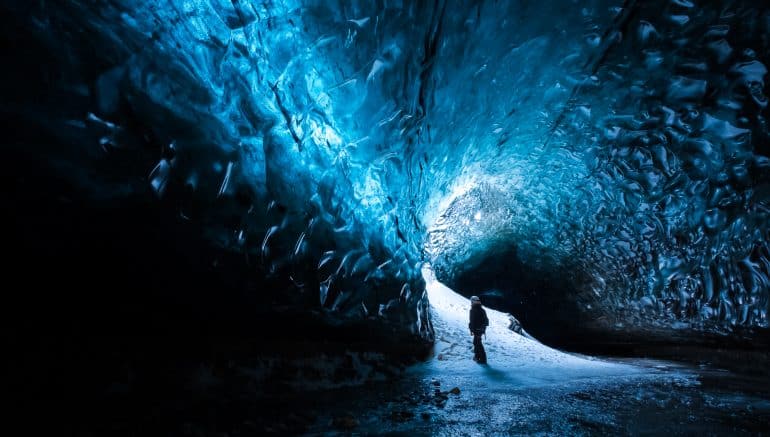 Un hombre admirando una cueva de hielo en Islandia.
