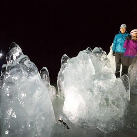 Deux personnes devant d'énormes morceaux de glace dans la grotte de Lofthellir, au nord de l'Islande.