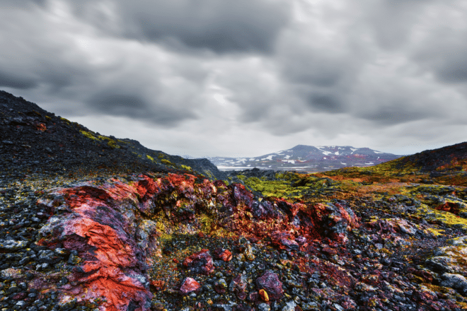 A colorful lava field by Leirhnjukur Volcano near Lake Mývarn in North Iceland. Cloudy sky.