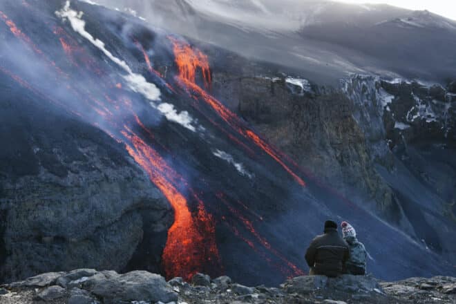Couple watching volcanic lava at Fimmvorduhals, Iceland