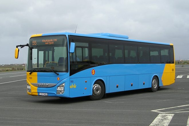 A blue and yellow bus on a parking lot.