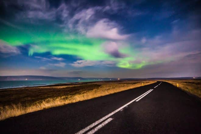 Northern Lights sobre una carretera vacía en Islandia