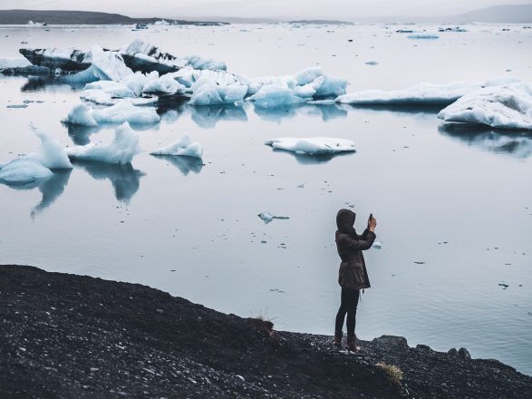 A person taking a photo of Jokulsarlon Glacier Lagoon in Southeast Iceland