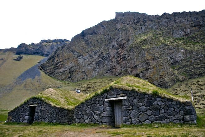 A turf house surrounded by mountains in the Westman Islands