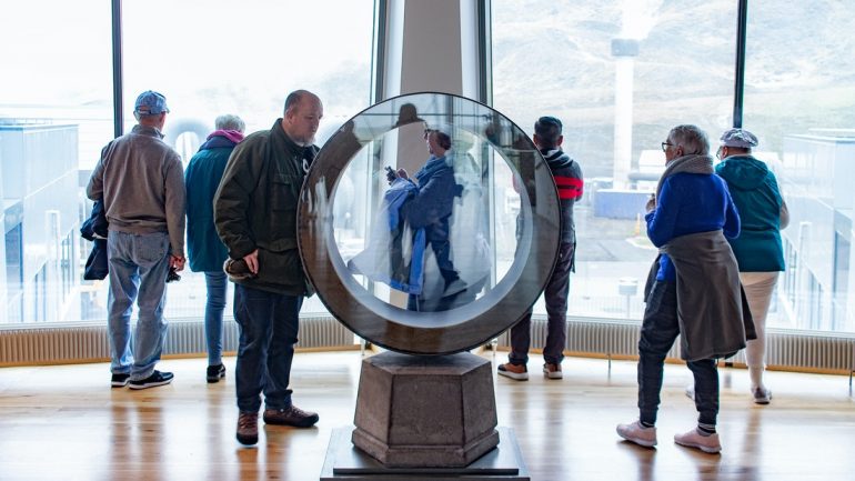 Personas explorando una escultura en la exposición geotérmica ON en el sur de Islandia