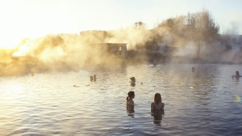 Des gens dans de l'eau géothermique chaude au Secret Lagoon, dans le sud de l'Islande.