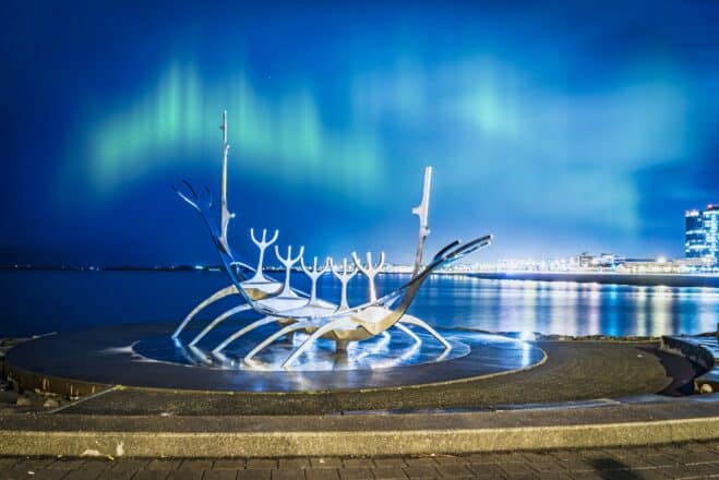Luces del norte bailando en el cielo sobre la escultura Sun Voyager en Reykjavik, Islandia