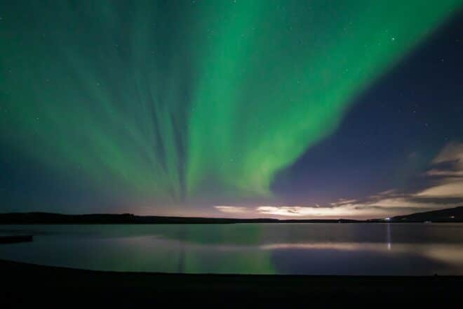 Green northern lights above a lake in Iceland