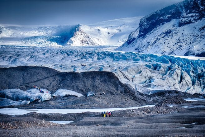 Grupos de senderismo por glaciares frente a un glaciar en la Reserva Natural de Skaftafell