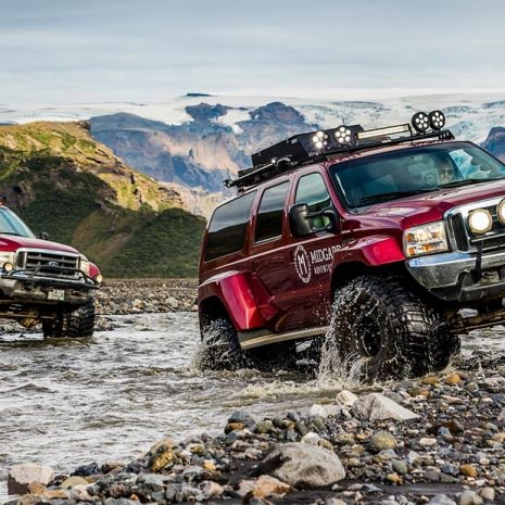 Deux jeeps traversant une rivière dans les hautes terres islandaises.