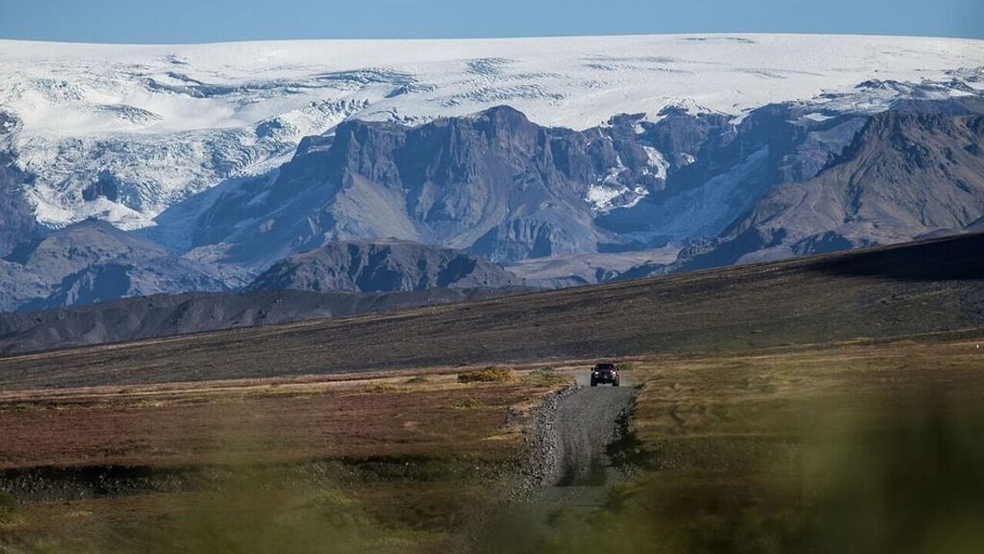 A car driving on a road in the Icelandic Highlands.