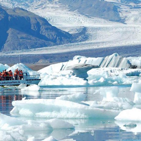 Un barco que navega entre icebergs en la laguna glaciar de Jokulsarlon, Islandia