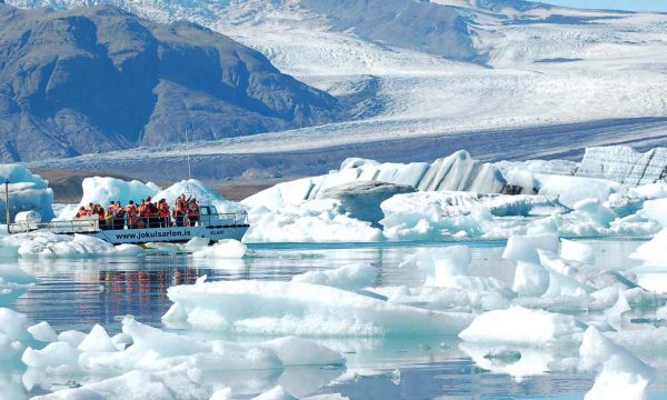 Un bateau naviguant parmi les icebergs à Jokulsarlon Glacier Lagoon, Islande