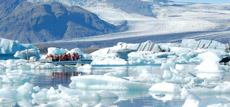 Un bateau naviguant parmi les icebergs à Jokulsarlon Glacier Lagoon, Islande
