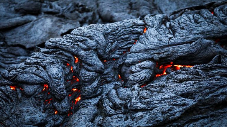 Lava negra en Islandia con vetas de magma rojo brillante saliendo