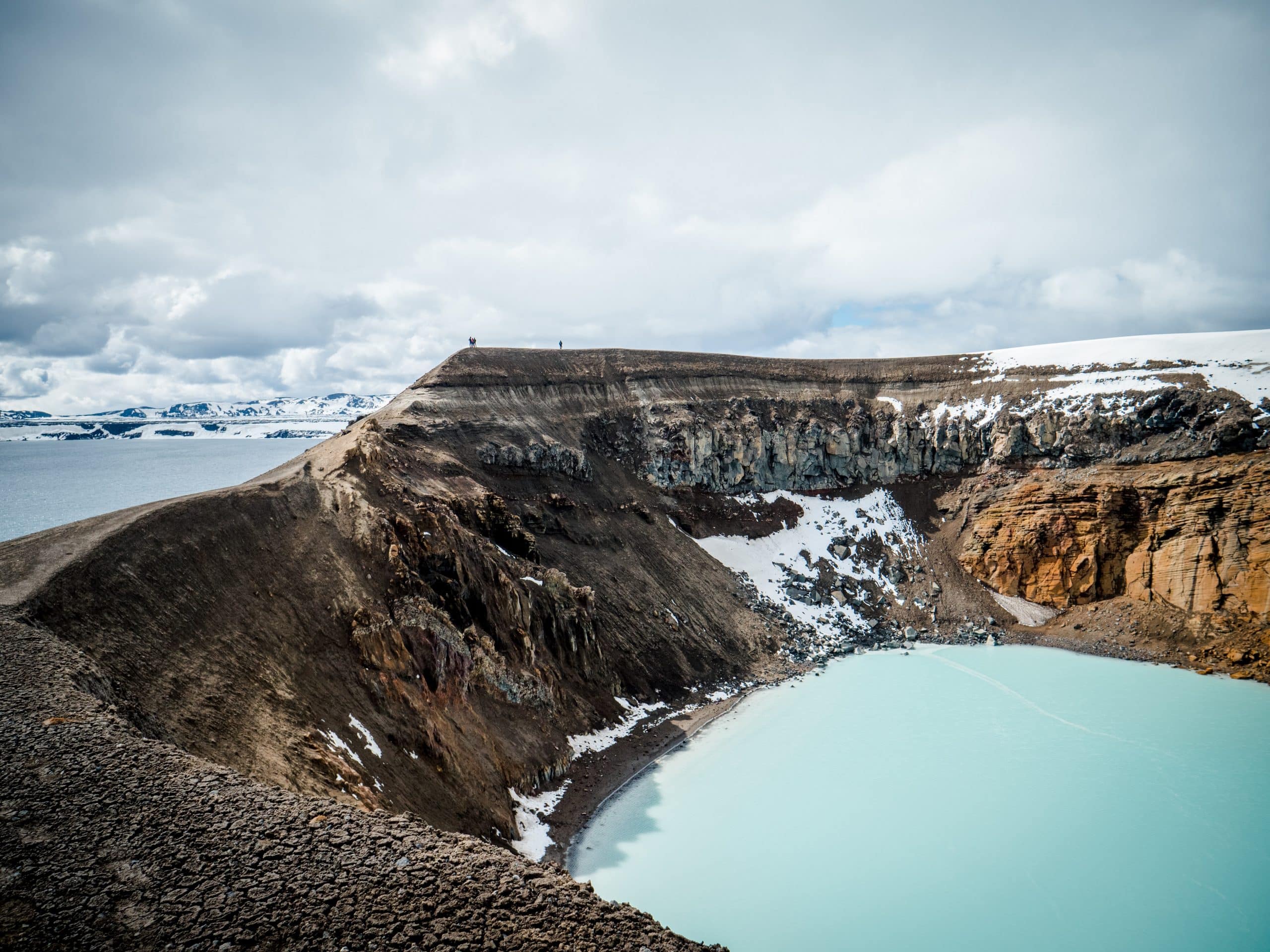 Lac bleu et montagnes enneigées dans les hautes terres islandaises.
