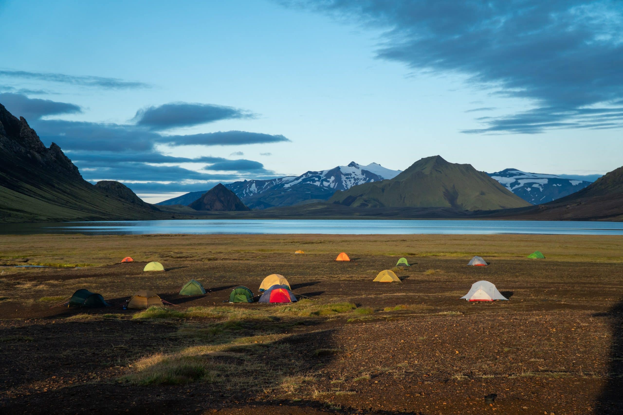 Tentes dans un camping dans les hautes terres islandaises, surplombant un lac.