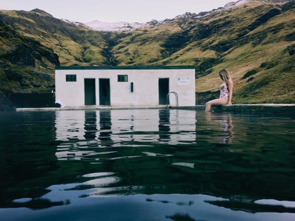 Une femme dans la piscine de Seljavallalaug dans le sud de l'Islande.
