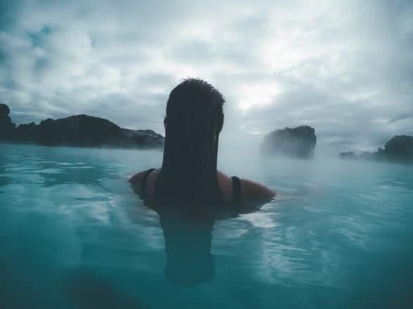 Mujer nadando en aguas termales en Islandia