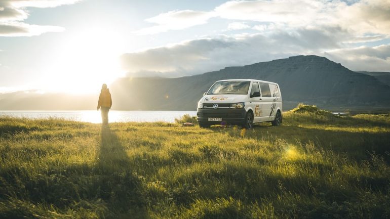 Une personne devant un camping-car en Islande