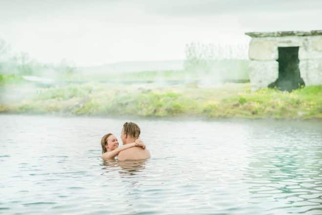 pareja joven relajándose en una laguna secreta en el sur de Islandia