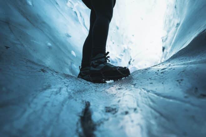 Explorador femenino en la cueva de hielo, Islandia