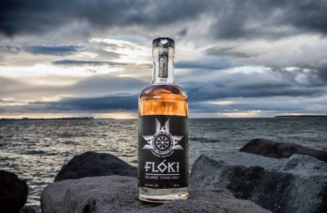 Whisky islandés sobre rocas oscuras en un día nublado.