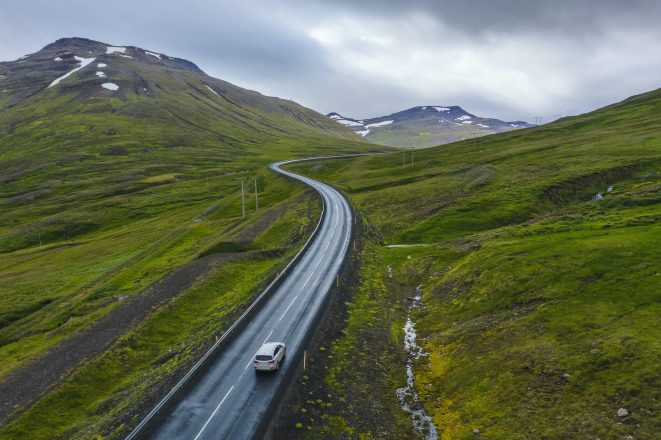 Coche de alquiler solitario en una carretera remota con hermosos paisajes de Islandia.