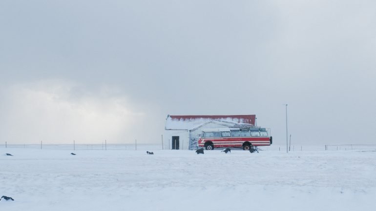 Un autobús rojo en una tormenta de nieve en Islandia