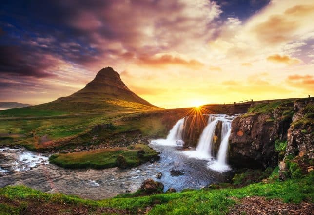 La pintoresca puesta de sol sobre paisajes y cascadas. Montaña de Kirkjufell, Islandia