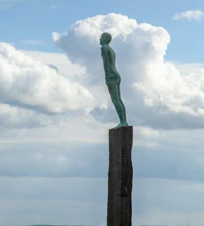 Estatua de un hombre contra un cielo azul en Vik, Islandia
