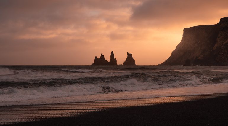 Coucher de soleil sur une plage de sable noir à Vik, sud de l'Islande