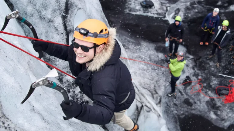 Un hombre sonriendo en un tour de escalada en hielo en Islandia