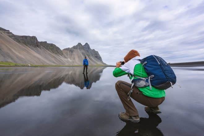 El fotógrafo toma una foto cerca de las famosas montañas Stokksnes en el cabo Vestrahorn, Islandia