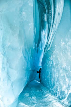 A person standing inside a blue ice cave on Langjökull glacier in Iceland.