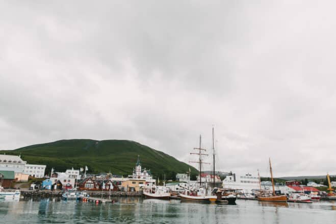 boats in harbour and buildings on coast in icelandic port husavik