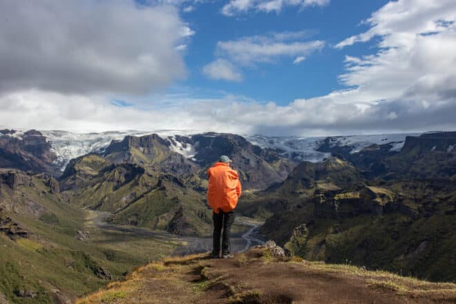 Un homme debout devant des montagnes et des glaciers dans les hautes terres islandaises