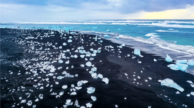 Glace éparpillée sur une plage de sable noir à la Diamond Beach en Islande.
