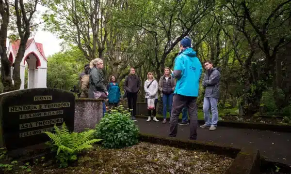 A guide standing in front of a group of people inside a cemetery in Reykjavik, Iceland