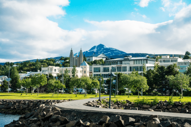 A walking path in Akureyri, Iceland with Mt. Hlíðarfjall and Akureyri Church in the background.