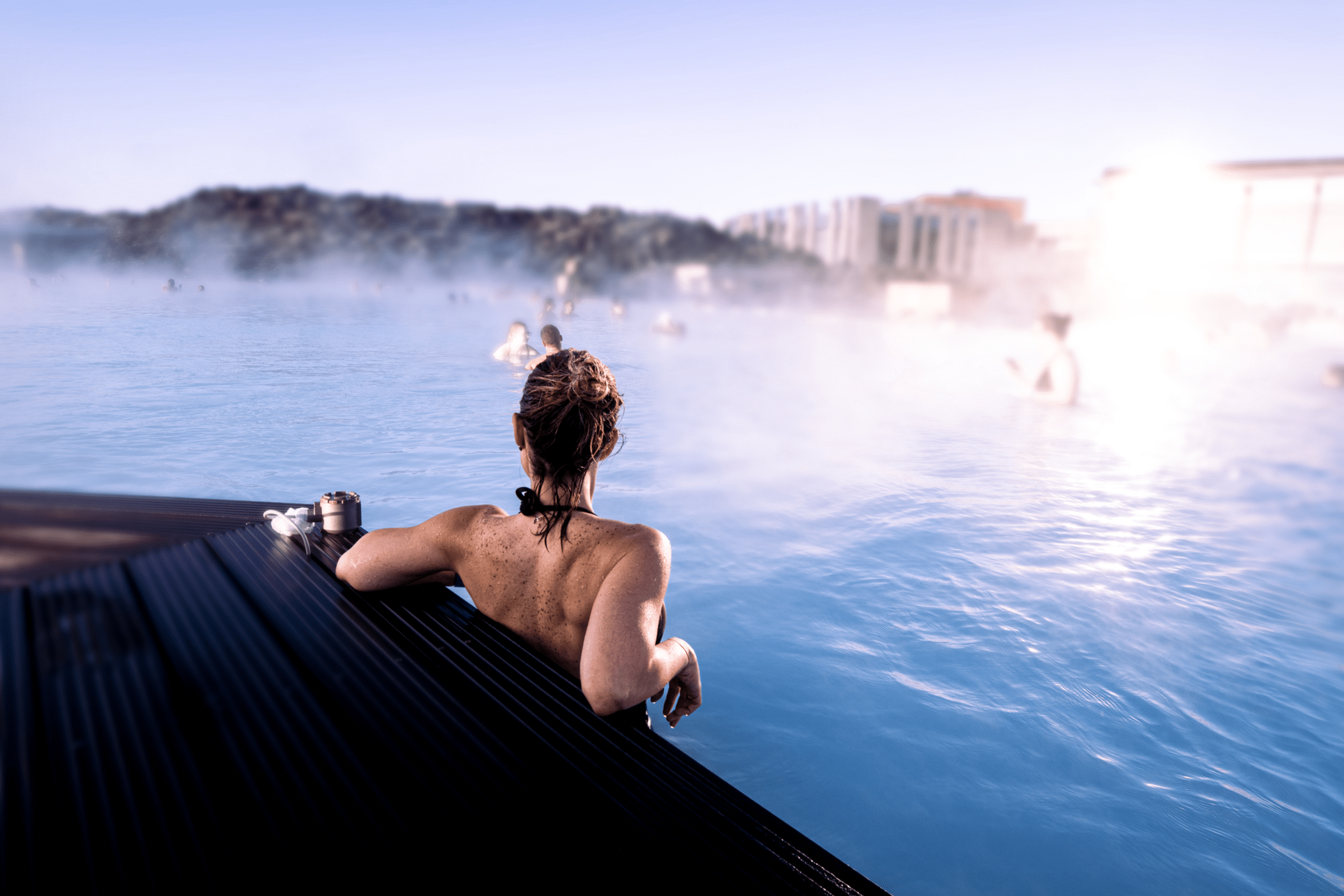 Mujer joven disfrutando de un baño relajante en el famoso baño termal Blue Lagoon en Islandia.