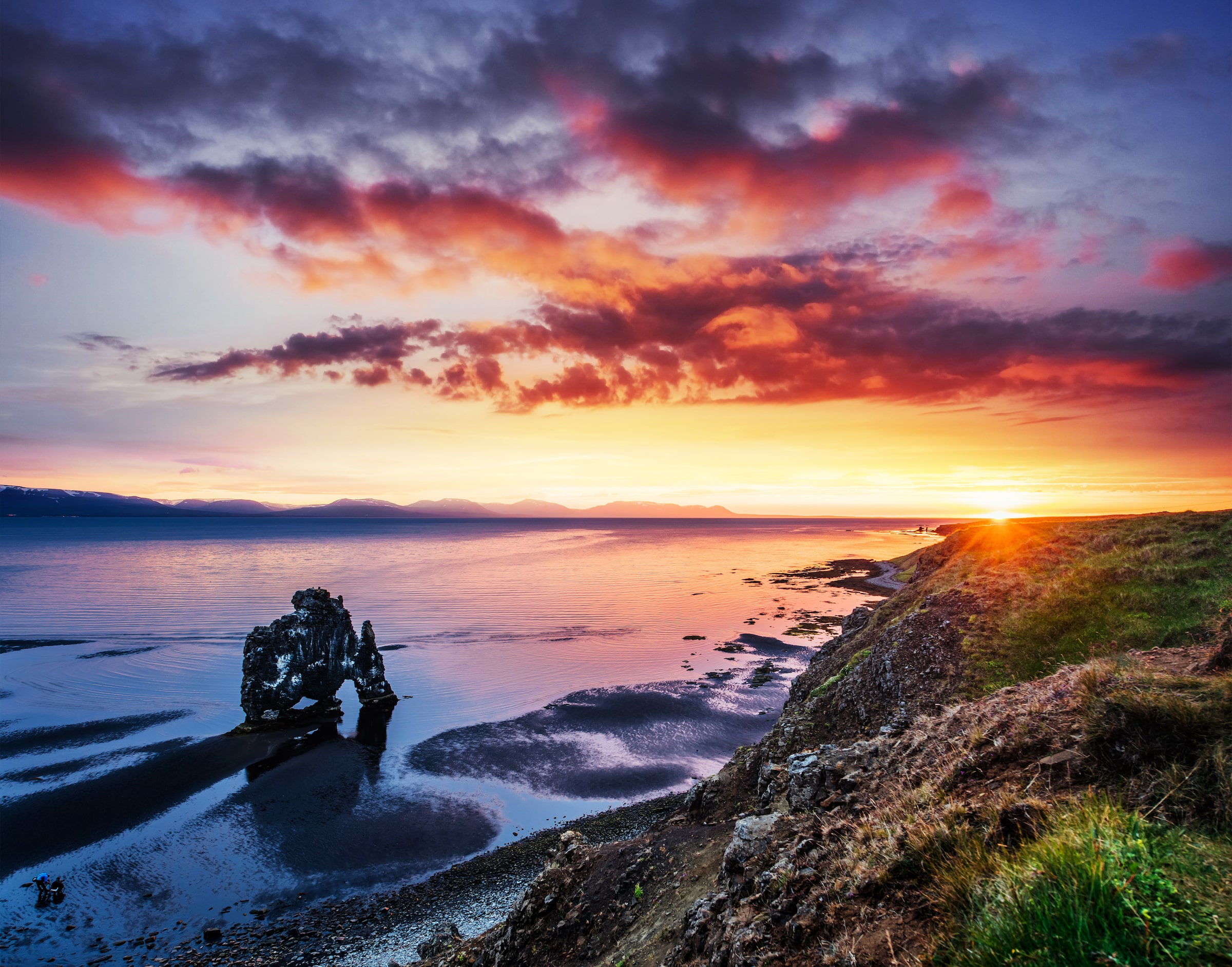 Hvitserkur Rock dans le nord de l'Islande se reflète dans l'eau de mer au coucher du soleil.